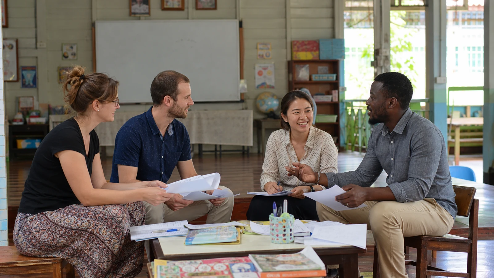 A supportive group of foreign teachers sharing ideas in a Thai school